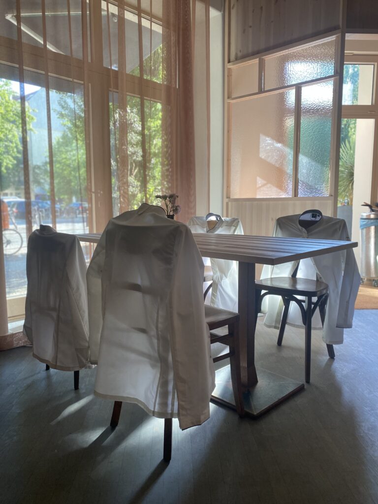 Kochjacken hängen über Stuhllehnen im Gegenlicht