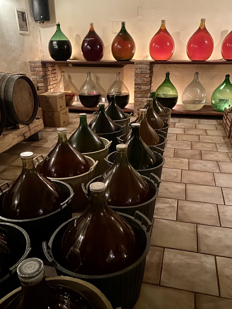 Glasballons gefüllt mit Naturwein und Likören